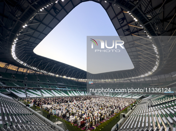 Worshipers are performing Eid al-Adha prayers at the Education City Stadium on the first day of the Eid al-Adha holiday in Doha, Qatar, on J...