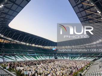 Worshipers are performing Eid al-Adha prayers at the Education City Stadium on the first day of the Eid al-Adha holiday in Doha, Qatar, on J...