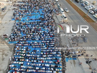 Muslims in Syria perform Eid al-Adha prayers in an open-air area in Bab al-Hawa Square, in the countryside of Idlib, northwest Syria, on the...