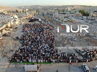 Muslims in Syria perform Eid al-Adha prayers in an open-air area in Bab al-Hawa Square, in the countryside of Idlib, northwest Syria, on the...