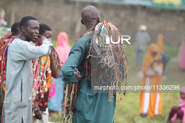 Prayer beads sellers are chatting as Muslim faithful are praying to mark the Eid-El-Kabir festival in Ikeja, Lagos, Nigeria, on Sunday, June...