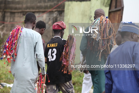 Prayer beads sellers are walking away as Muslim faithful are praying to mark the Eid-El-Kabir festival in Ikeja, Lagos, Nigeria, on Sunday,...