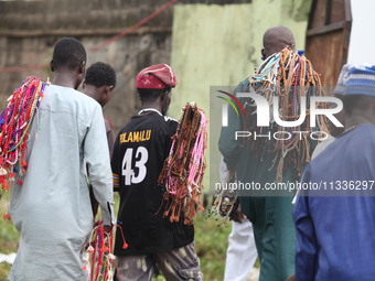 Prayer beads sellers are walking away as Muslim faithful are praying to mark the Eid-El-Kabir festival in Ikeja, Lagos, Nigeria, on Sunday,...