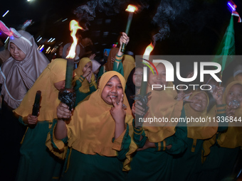 Hundreds of participants are carrying lanterns and posters as they celebrate Eid al-Adha on the city streets in Malang, East Java, Indonesia...