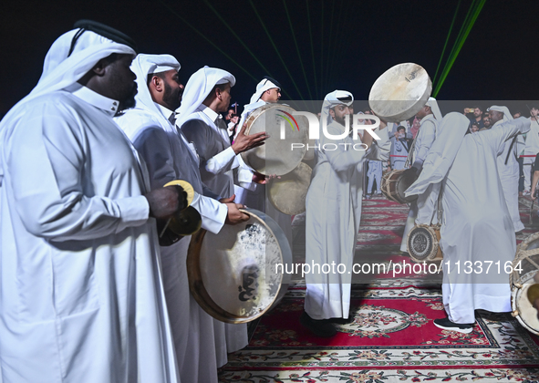 A Qatari traditional band is performing during the celebration of the first day of the Eid Al-Adha festival at Katara Cultural Village in Do...