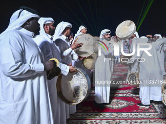 A Qatari traditional band is performing during the celebration of the first day of the Eid Al-Adha festival at Katara Cultural Village in Do...