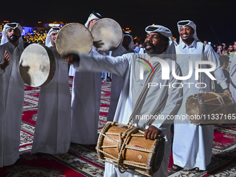 A Qatari traditional band is performing during the celebration of the first day of the Eid Al-Adha festival at Katara Cultural Village in Do...