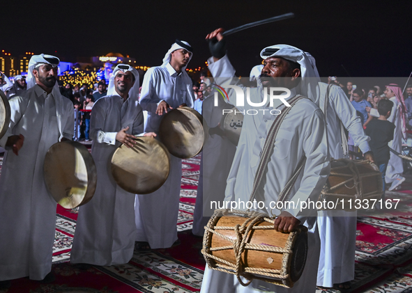 A Qatari traditional band is performing during the celebration of the first day of the Eid Al-Adha festival at Katara Cultural Village in Do...