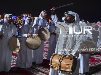 A Qatari traditional band is performing during the celebration of the first day of the Eid Al-Adha festival at Katara Cultural Village in Do...