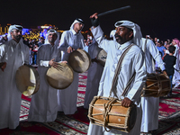 A Qatari traditional band is performing during the celebration of the first day of the Eid Al-Adha festival at Katara Cultural Village in Do...