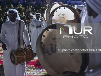 A Qatari traditional band is performing during the celebration of the first day of the Eid Al-Adha festival at Katara Cultural Village in Do...