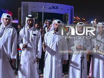 A Qatari traditional band is performing during the celebration of the first day of the Eid Al-Adha festival at Katara Cultural Village in Do...