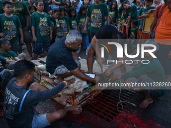 (EDITOR'S NOTE: Graphic content) Residents are watching the slaughtering of a goat during the Eid al-Adha celebration in the courtyard of th...