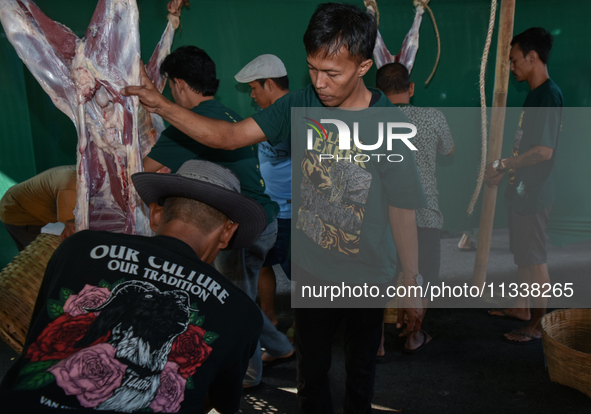 Residents are working together to cut hundreds of goats to be distributed to the public during the Eid al-Adha celebration at the Nur Mosque...