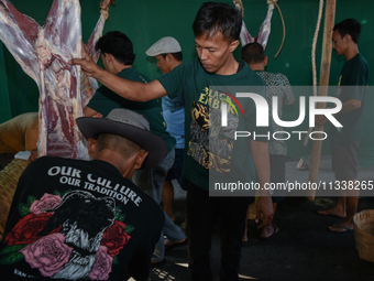 Residents are working together to cut hundreds of goats to be distributed to the public during the Eid al-Adha celebration at the Nur Mosque...