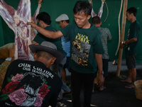 Residents are working together to cut hundreds of goats to be distributed to the public during the Eid al-Adha celebration at the Nur Mosque...