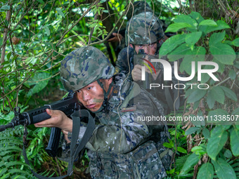 Officers and soldiers are conducting a comprehensive anti-terrorism drill in the wild in an unfamiliar area in Beihai, China, on June 17, 20...