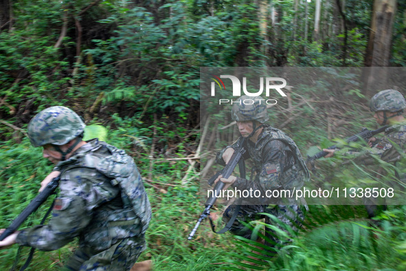 Officers and soldiers are conducting a comprehensive anti-terrorism drill in the wild in an unfamiliar area in Beihai, China, on June 17, 20...