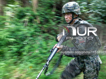 Officers and soldiers are conducting a comprehensive anti-terrorism drill in the wild in an unfamiliar area in Beihai, China, on June 17, 20...