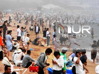 Tourists are enjoying the cool water at the No. 1 Bathing Beach in Qingdao, China, on June 17, 2024. (