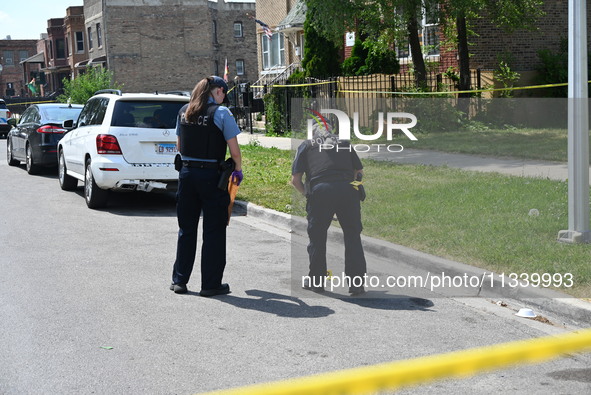 The crime scene unit is collecting evidence. Two people are being shot on W. Maple Street in Chicago, Illinois, United States, on June 17, 2...