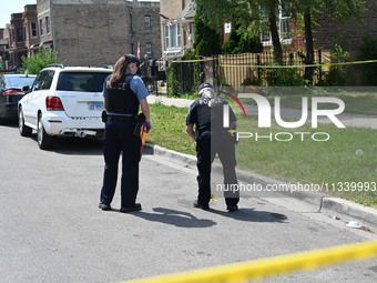 The crime scene unit is collecting evidence. Two people are being shot on W. Maple Street in Chicago, Illinois, United States, on June 17, 2...