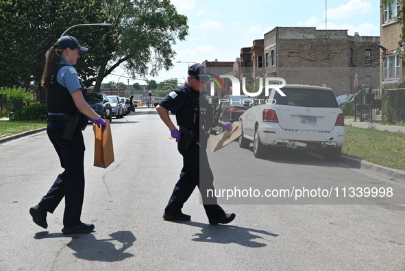 The crime scene is collecting evidence at the crime scene. Two people are being shot on W. Maple Street in Chicago, Illinois, United States,...