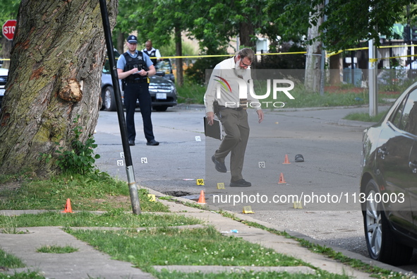 Several shell casings are being discovered on the scene. Two people are being shot on S. Burnside Avenue in Chicago, Illinois, United States...