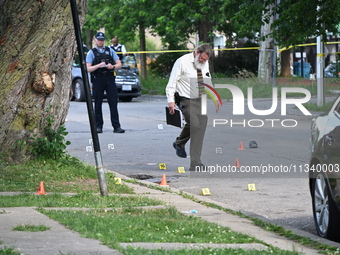 Several shell casings are being discovered on the scene. Two people are being shot on S. Burnside Avenue in Chicago, Illinois, United States...