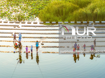 Citizens are bringing their children to play, fish, and catch lobsters at a wetland park in Suqian, Jiangsu province, China, on June 17, 202...