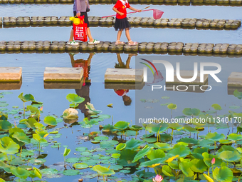 Citizens are bringing their children to play, fish, and catch lobsters at a wetland park in Suqian, Jiangsu province, China, on June 17, 202...