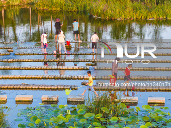 Citizens are bringing their children to play, fish, and catch lobsters at a wetland park in Suqian, Jiangsu province, China, on June 17, 202...