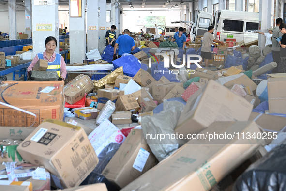 Workers are sorting parcels at an express logistics company in Taicang, China, on June 18, 2024. 