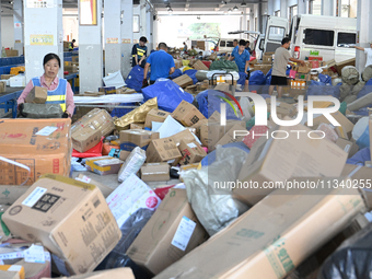 Workers are sorting parcels at an express logistics company in Taicang, China, on June 18, 2024. (