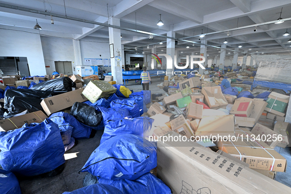 Workers are sorting parcels at an express logistics company in Taicang, China, on June 18, 2024. 