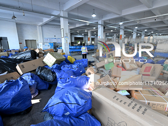 Workers are sorting parcels at an express logistics company in Taicang, China, on June 18, 2024. (