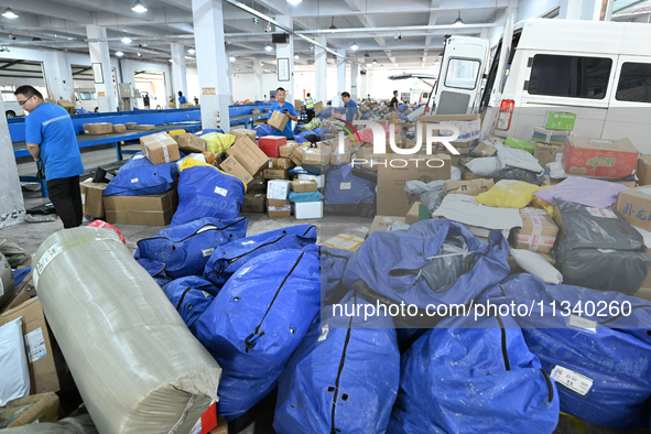 Workers are sorting parcels at an express logistics company in Taicang, China, on June 18, 2024. 