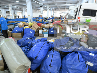 Workers are sorting parcels at an express logistics company in Taicang, China, on June 18, 2024. (