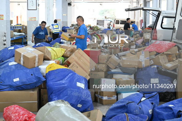 Workers are sorting parcels at an express logistics company in Taicang, China, on June 18, 2024. 