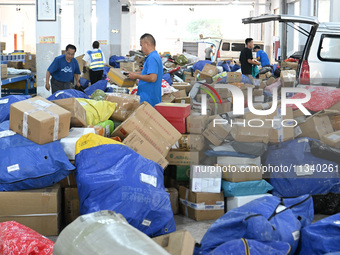 Workers are sorting parcels at an express logistics company in Taicang, China, on June 18, 2024. (