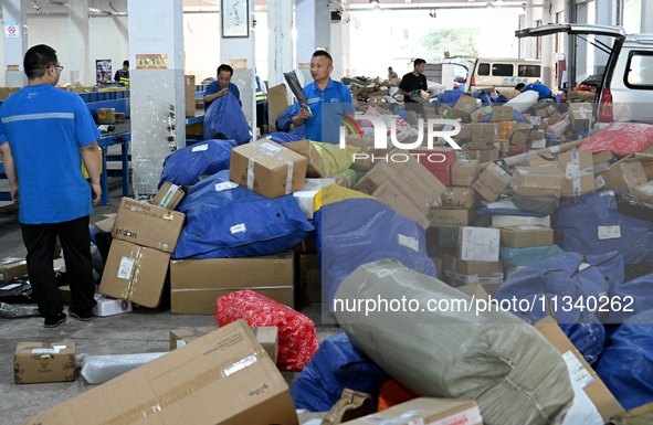 Workers are sorting parcels at an express logistics company in Taicang, China, on June 18, 2024. 