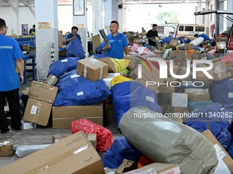 Workers are sorting parcels at an express logistics company in Taicang, China, on June 18, 2024. (