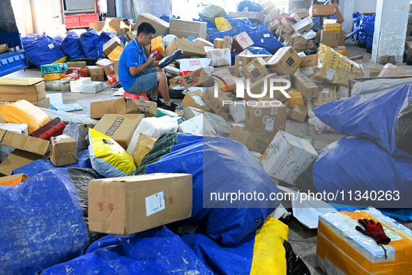 Workers are sorting parcels at an express logistics company in Taicang, China, on June 18, 2024. 