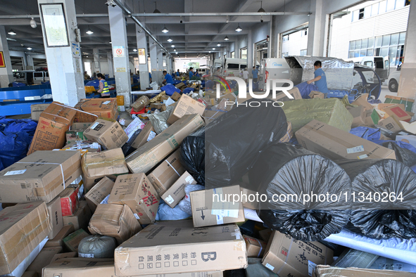 Workers are sorting parcels at an express logistics company in Taicang, China, on June 18, 2024. 