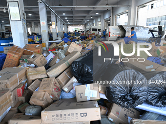 Workers are sorting parcels at an express logistics company in Taicang, China, on June 18, 2024. (