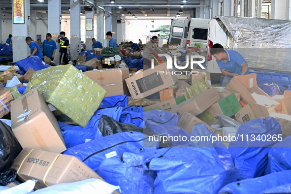 Workers are sorting parcels at an express logistics company in Taicang, China, on June 18, 2024. 