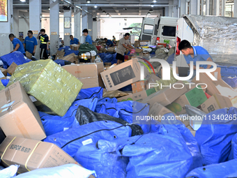 Workers are sorting parcels at an express logistics company in Taicang, China, on June 18, 2024. (