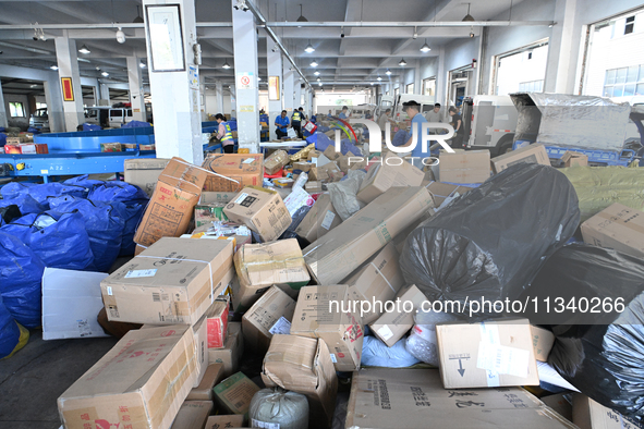 Workers are sorting parcels at an express logistics company in Taicang, China, on June 18, 2024. 