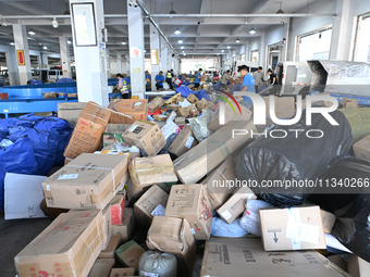 Workers are sorting parcels at an express logistics company in Taicang, China, on June 18, 2024. (