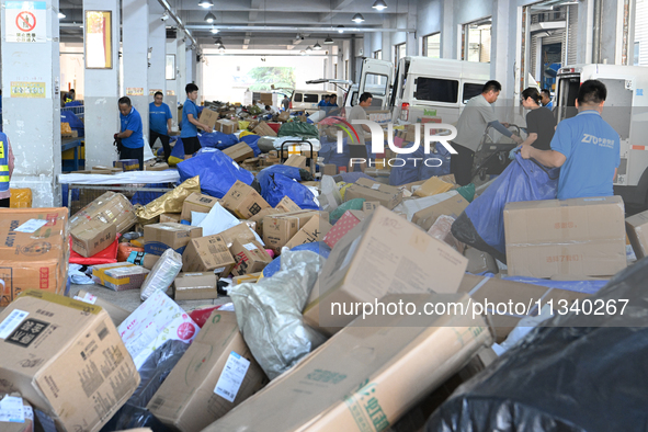 Workers are sorting parcels at an express logistics company in Taicang, China, on June 18, 2024. 